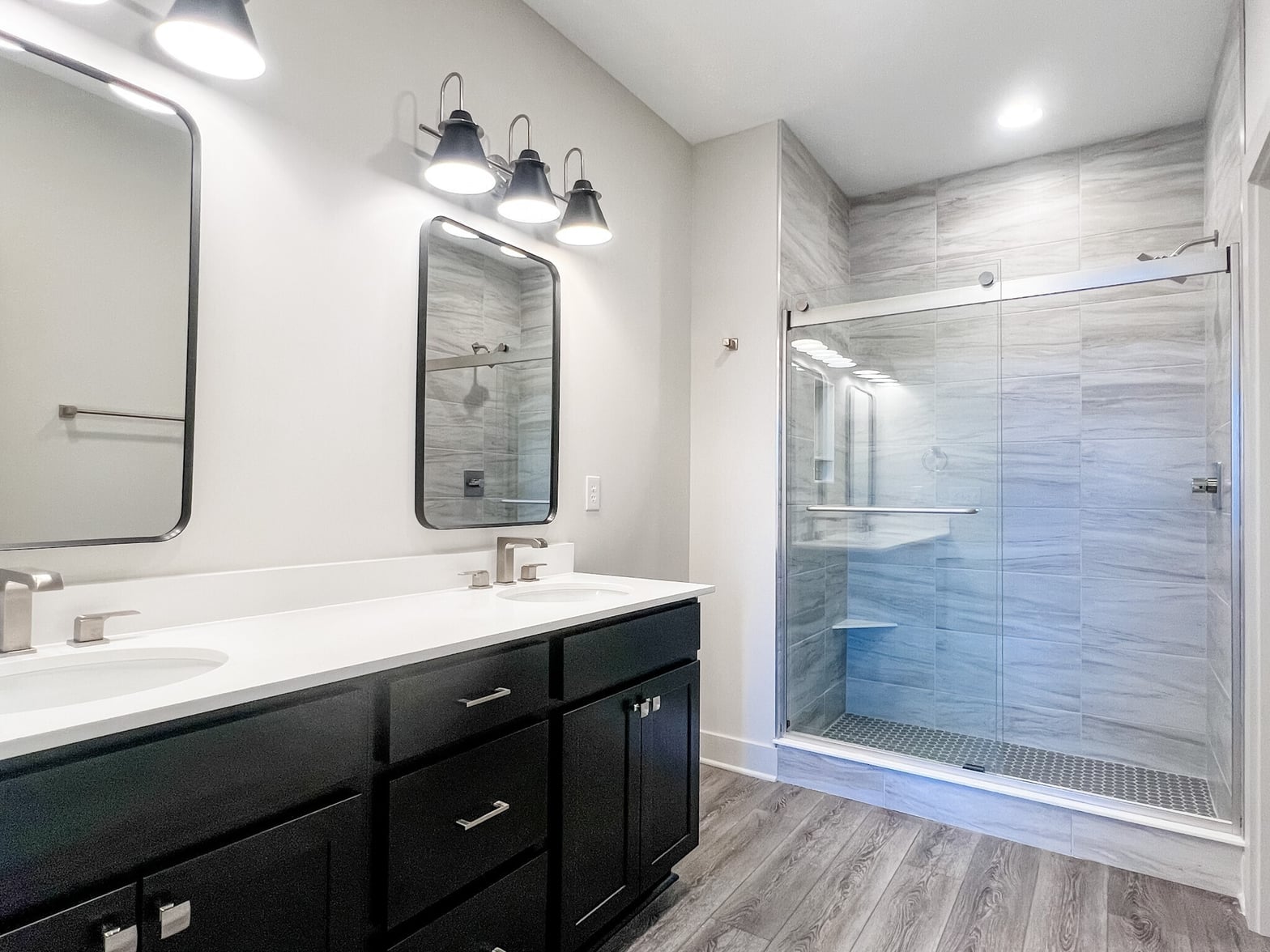 Spa-inspired primary bath with dual vanity and frameless shower.