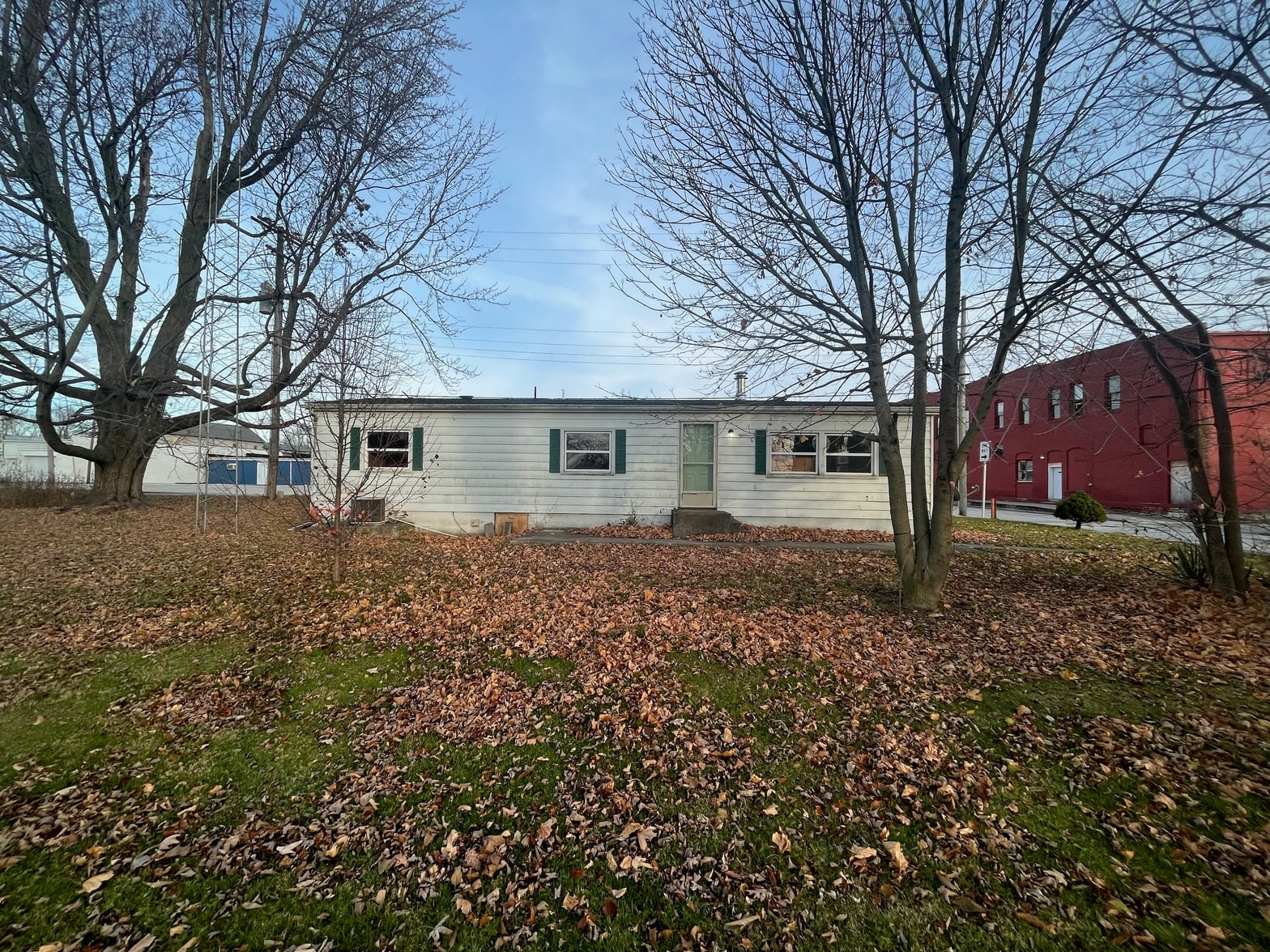 Front exterior at 106 W Water Street, Converse, IN — Spacious lot with mature trees and peaceful rural setting.