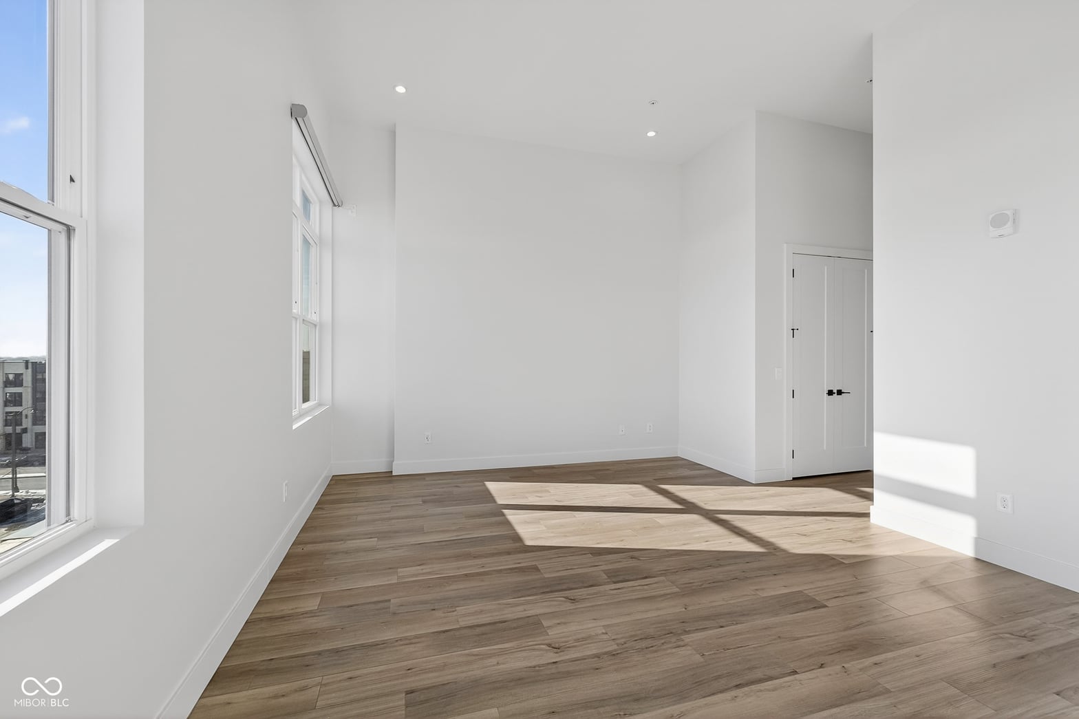Bright corner bedroom flooded with natural light and modern finishes.