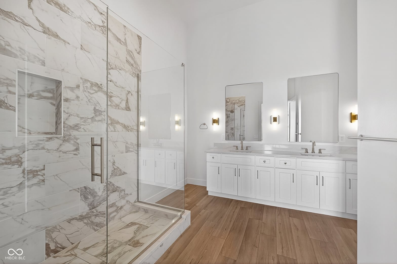 Spa-like primary bath with marble shower and dual vanity.