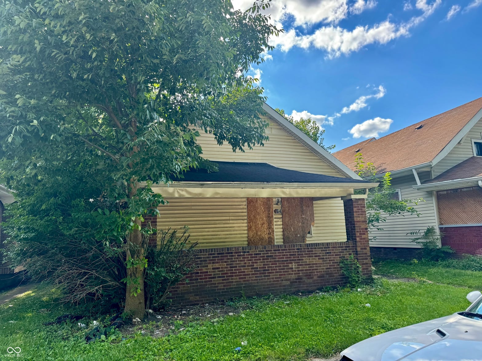 Front exterior at 642 N Oxford Street, Indianapolis, IN — Brick ranch with mature trees needing updates.