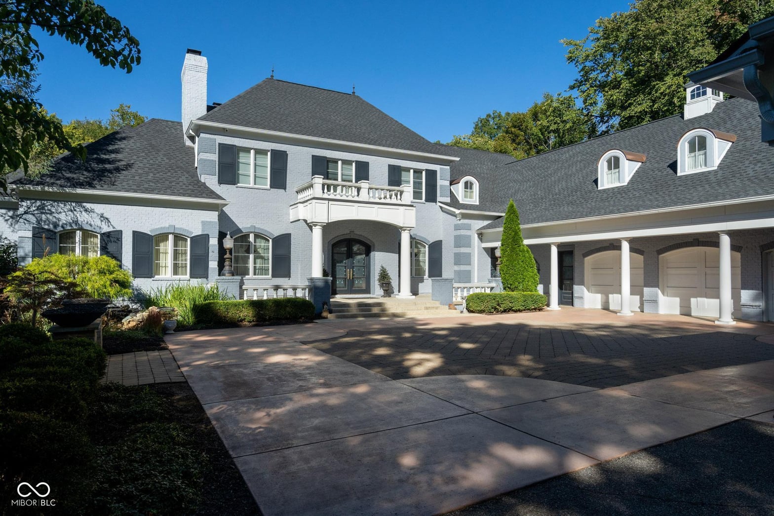Front exterior at 8358 Hidden Point Drive, Indianapolis, IN — Elegant brick estate with grand entry and manicured grounds.