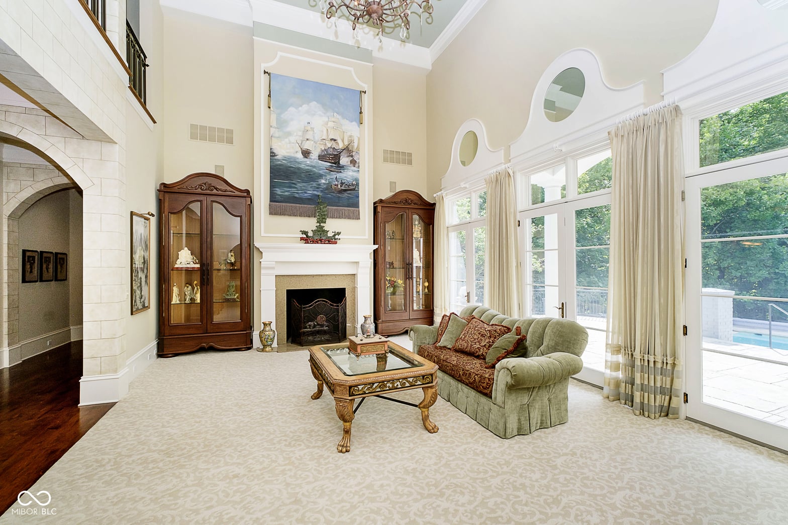 Living room at 8358 Hidden Point Drive, Indianapolis, IN — Soaring ceilings and walls of glass frame luxury living.