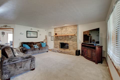 Family room at 303 Wellington Overlook, Noblesville, IN — Spacious family room anchored by charming brick fireplace.