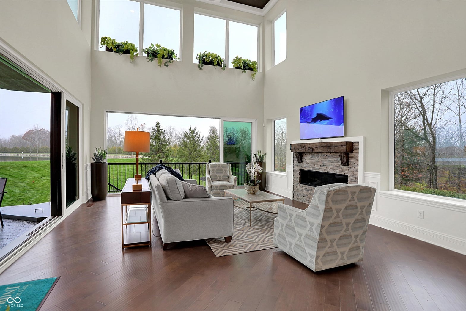 Bright modern family room with fireplace and expansive windows.