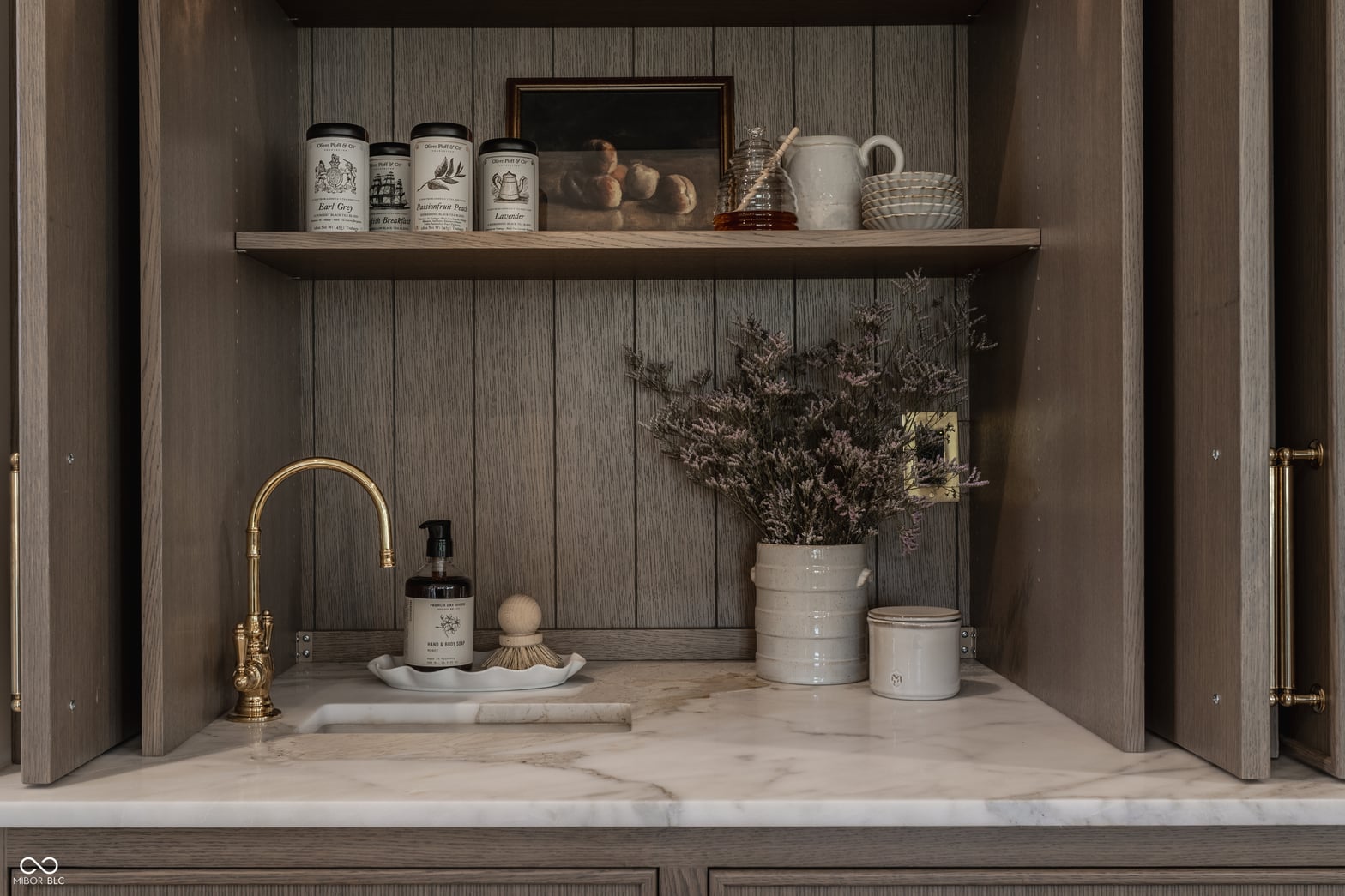 Elegant farmhouse bath with marble counters and styled shelving.