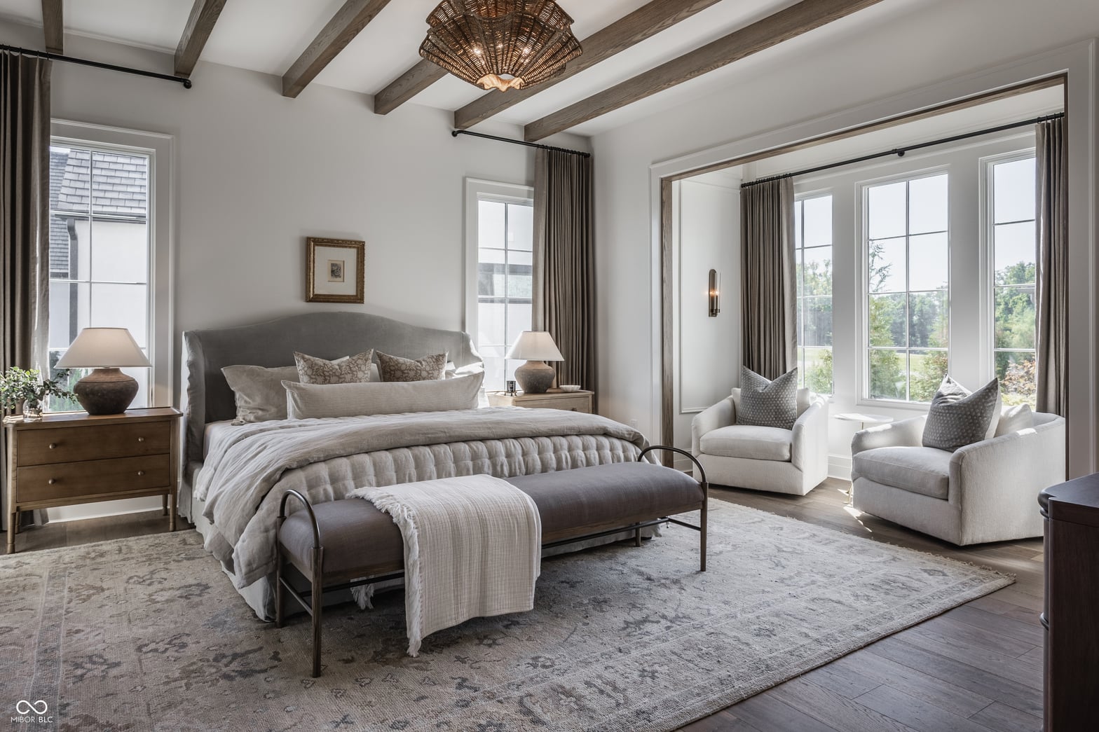 Luxurious primary suite with beamed ceilings and expansive windows.