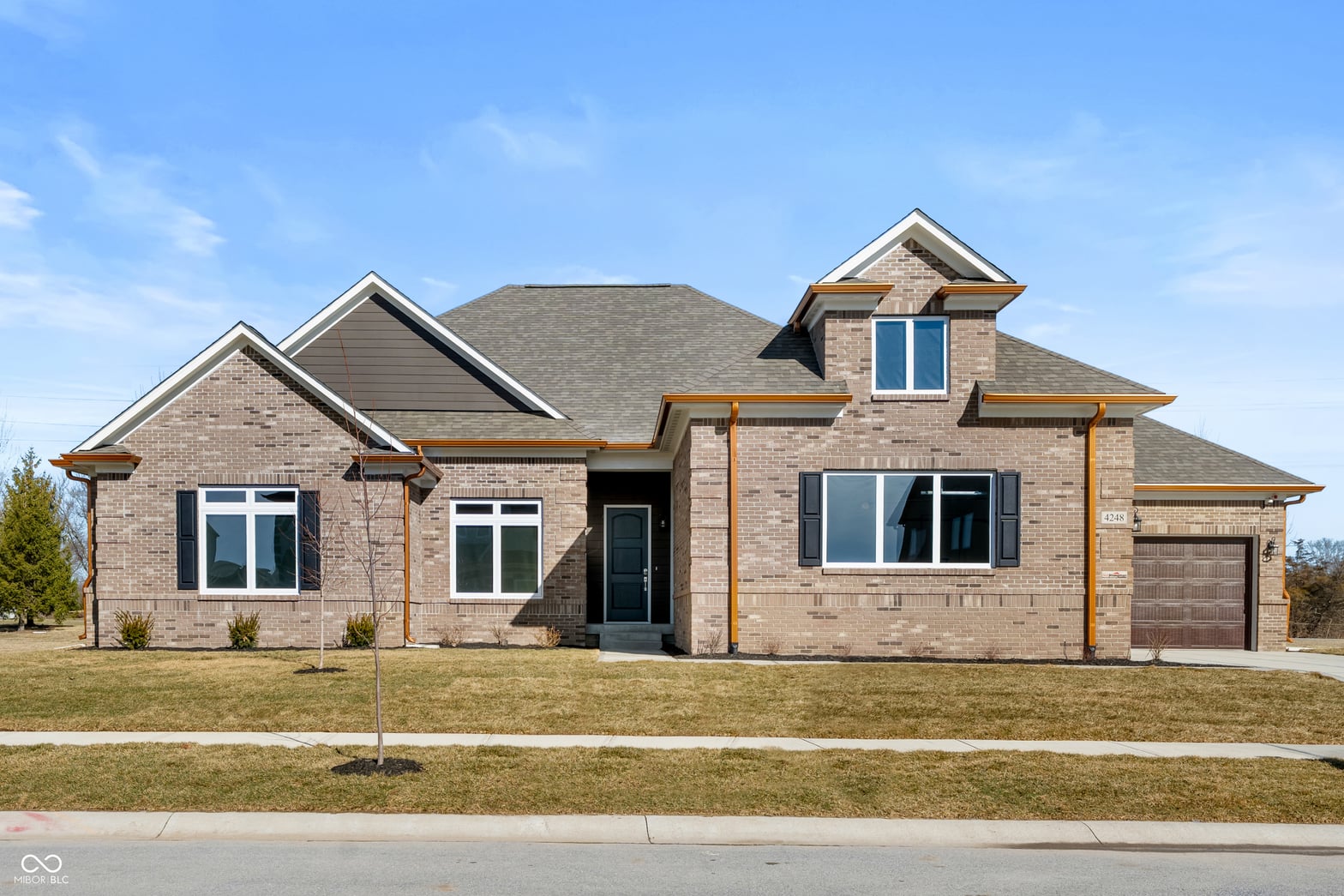Front exterior at 4248 Stone Lake Drive, Zionsville, IN — Striking brick contemporary with copper accents and gables.