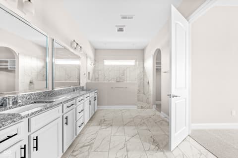 Primary bathroom at 4248 Stone Lake Drive, Zionsville, IN — Luxurious primary bath with marble finishes and dual vanity.