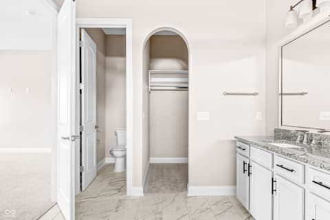 Primary bathroom at 4248 Stone Lake Drive, Zionsville, IN — Luxurious primary bath with walk-in closet and dual vanity.