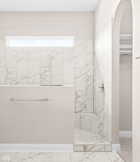 Primary bathroom at 4248 Stone Lake Drive, Zionsville, IN — Luxurious marble shower with frameless glass enclosure.