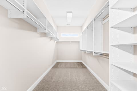 Primary bedroom at 4248 Stone Lake Drive, Zionsville, IN — Spacious walk-in closet with extensive shelving and storage.