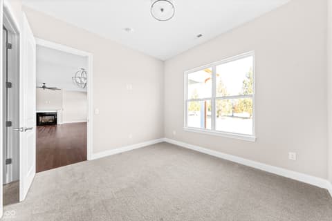 Bedroom at 4248 Stone Lake Drive, Zionsville, IN — Bright bedroom with large windows and fireplace views.