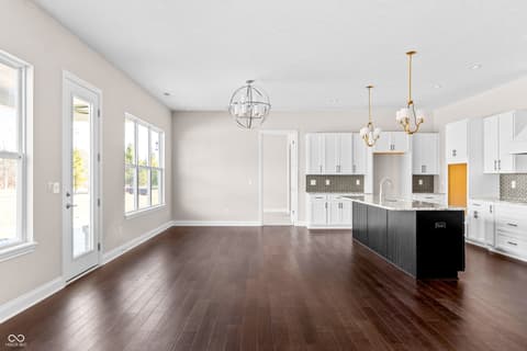 Kitchen at 4248 Stone Lake Drive, Zionsville, IN — Bright modern kitchen with hardwood floors and black island.