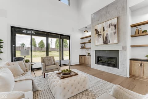 Living room at 16246 Remington Drive, Fishers, IN — Bright modern living room with fireplace and patio doors.
