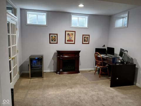Bonus room at 5983 Clearview Drive, Carmel, IN — Spacious finished basement with fireplace and work area.