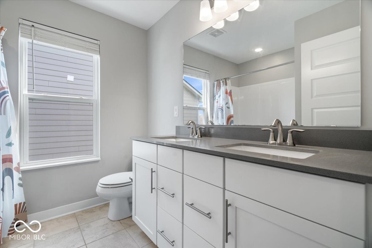 Spacious primary bath with dual vanity and modern finishes.