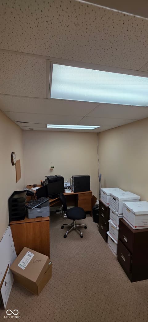 Home office at 22 W 8th Street, Anderson, IN — Functional office space with natural skylight and storage.