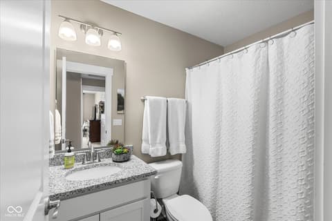 Primary bathroom at 14442 Treasure Creek Lane, Fishers, IN — Updated bathroom with granite counters and modern fixtures.