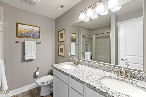 Primary bathroom at 14442 Treasure Creek Lane, Fishers, IN — Spacious primary bath with dual vanity and granite counters.