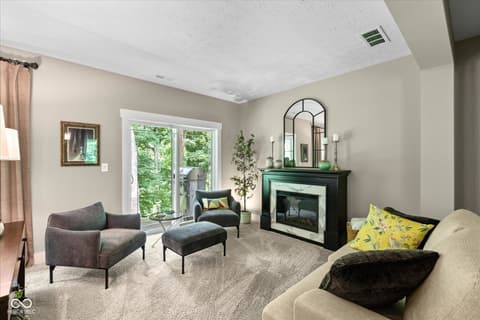 Living room at 14442 Treasure Creek Lane, Fishers, IN — Bright living room with fireplace and outdoor access.
