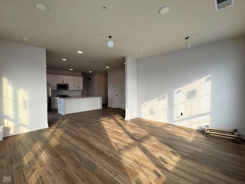 Living room at 925 Veterans Way, Carmel, IN — Bright open concept with hardwood floors and modern kitchen.