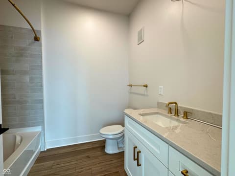 Primary bathroom at 925 Veterans Way, Carmel, IN — Newly built bathroom with marble counters and brass accents.