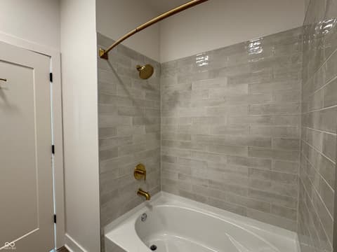 Bathroom at 925 Veterans Way, Carmel, IN — Modern bathroom with designer brass fixtures and spa tub.