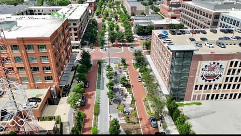 Aerial view at 925 Veterans Way, Carmel, IN — Modern urban development with green pedestrian corridor.