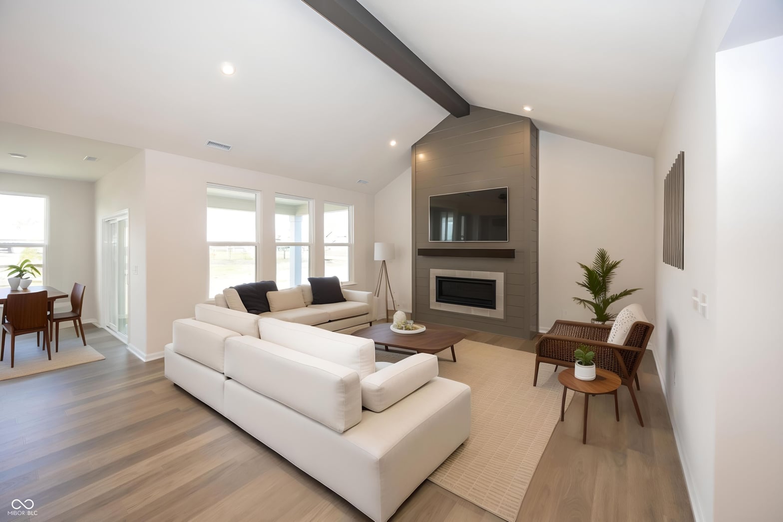 Bright contemporary living room with fireplace and exposed beams.