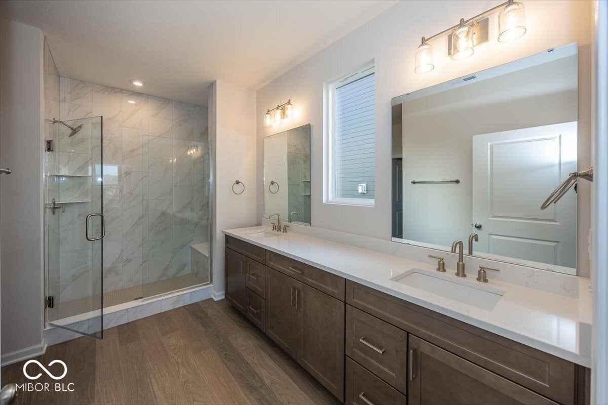 Luxurious primary bath with marble shower and double vanity.