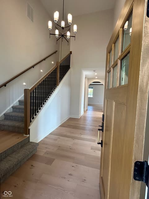 Foyer at 14565 Bedford Falls Drive, Carmel, IN — Bright modern foyer with elegant staircase and finishes.