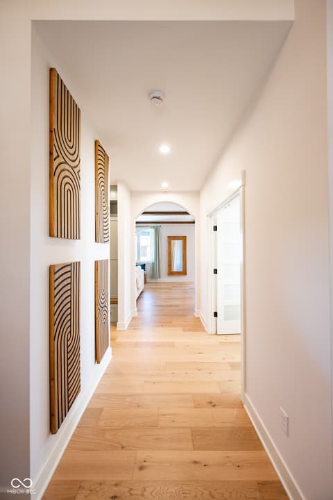 Hallway at 14565 Bedford Falls Drive, Carmel, IN — Bright modern hallway with artistic wood wall features.