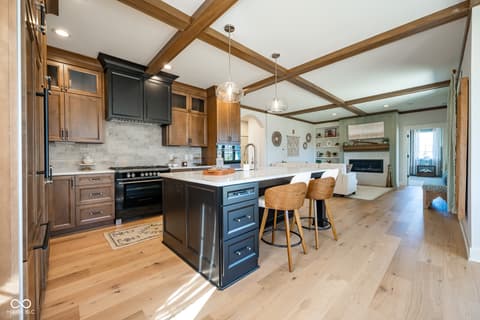Kitchen at 14565 Bedford Falls Drive, Carmel, IN — Stunning open-concept kitchen with exposed beams and island.