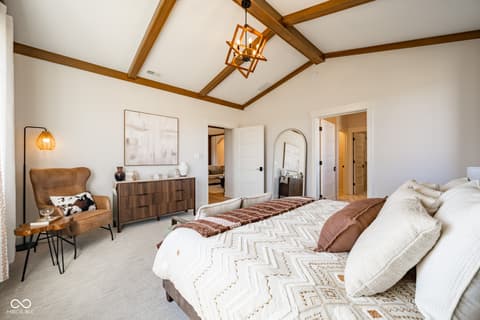 Primary bedroom at 14565 Bedford Falls Drive, Carmel, IN — Spacious primary suite with exposed beams and ensuite.