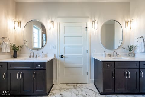 Primary bathroom at 14565 Bedford Falls Drive, Carmel, IN — Luxurious primary bath with dual vanities and marble floors.