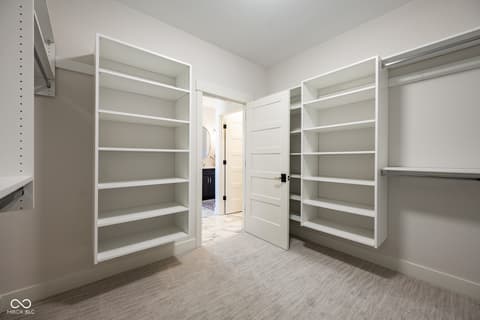 Primary bedroom at 14565 Bedford Falls Drive, Carmel, IN — Spacious walk-in closet with extensive built-in shelving.