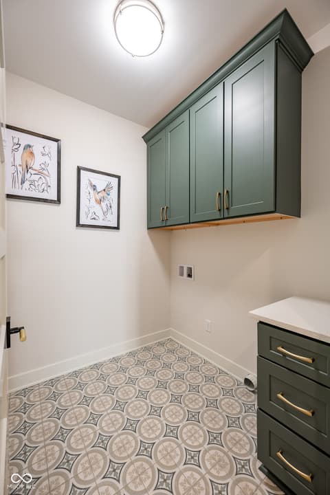 Laundry room at 14565 Bedford Falls Drive, Carmel, IN — Stylish renovated laundry room with custom green cabinetry.