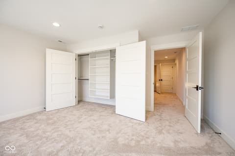 Primary bedroom at 14565 Bedford Falls Drive, Carmel, IN — Luxurious primary suite with expansive walk-in closet.