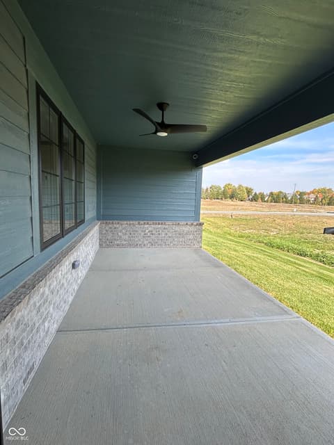 Front exterior at 14565 Bedford Falls Drive, Carmel, IN — Spacious covered front porch with rural views.