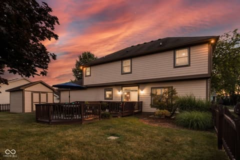 Backyard at 2025 W Morse Drive, Cicero, IN — Two-story home with spacious backyard deck at dusk.