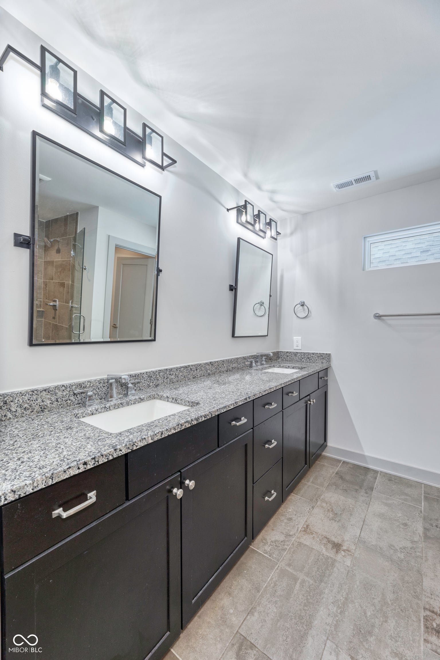 Luxurious primary bath with granite double vanity.