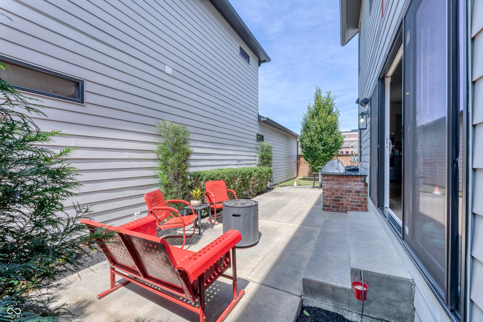 Modern patio space with fire pit and comfortable seating.