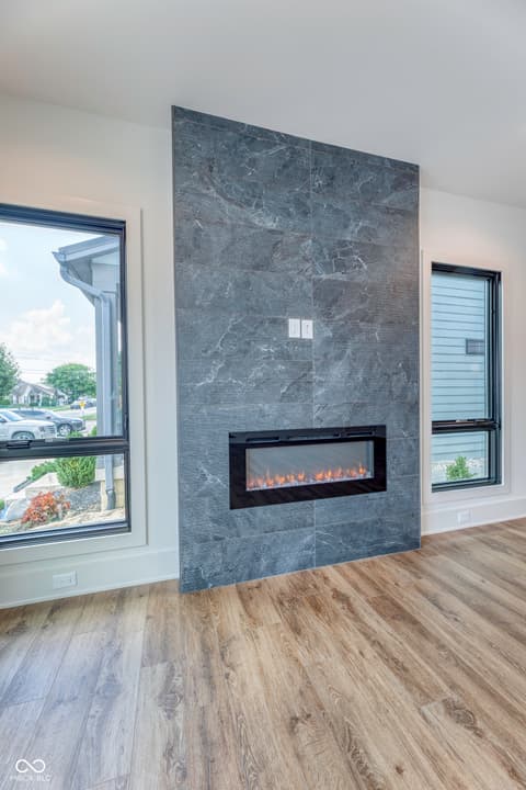 Living room at 8694 Morgan Drive, Fishers, IN — Stunning slate fireplace with electric insert and windows.