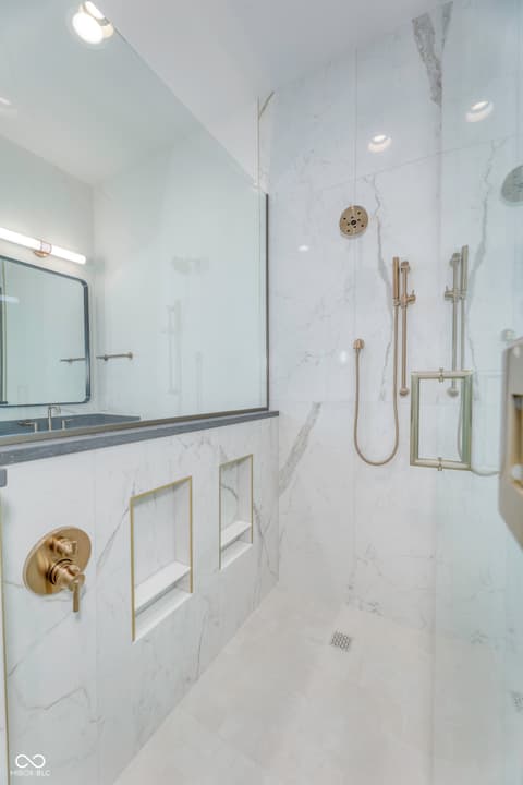 Primary bathroom at 8694 Morgan Drive, Fishers, IN — Luxurious marble spa bathroom with modern brass fixtures.