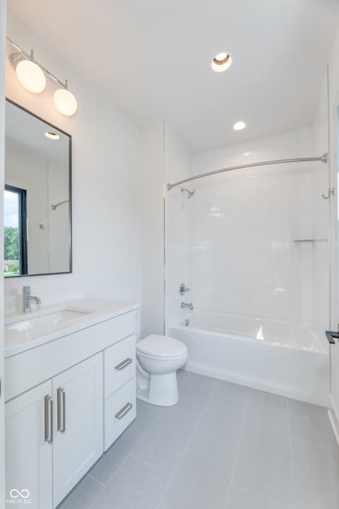 Primary bathroom at 8694 Morgan Drive, Fishers, IN — Bright, spa-like primary bath with frameless shower glass.