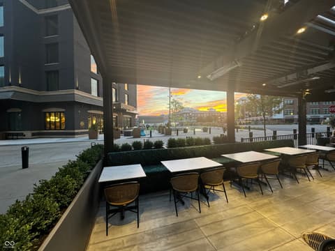 Outdoor living area at 8694 Morgan Drive, Fishers, IN — Modern covered outdoor dining with urban plaza views.