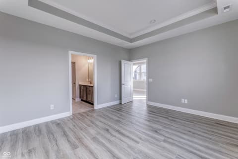 Primary bedroom at 14890 E Keenan Circle, Westfield, IN — Spacious primary suite with tray ceiling and ensuite bath.
