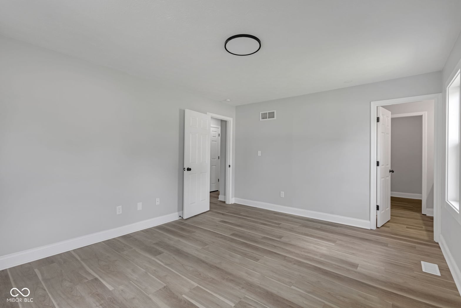 Spacious primary suite with hardwood floors and dual closets.