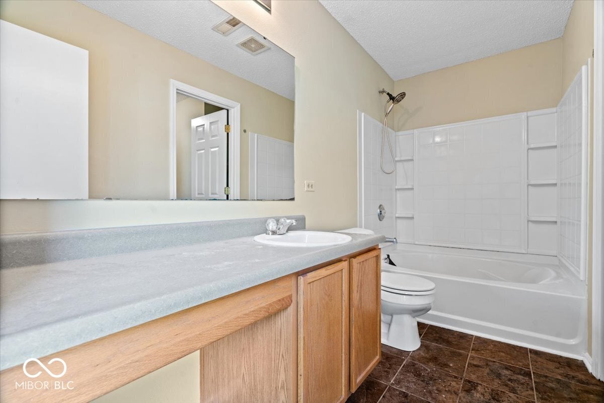 Spacious primary bath with dual vanity and granite counters.